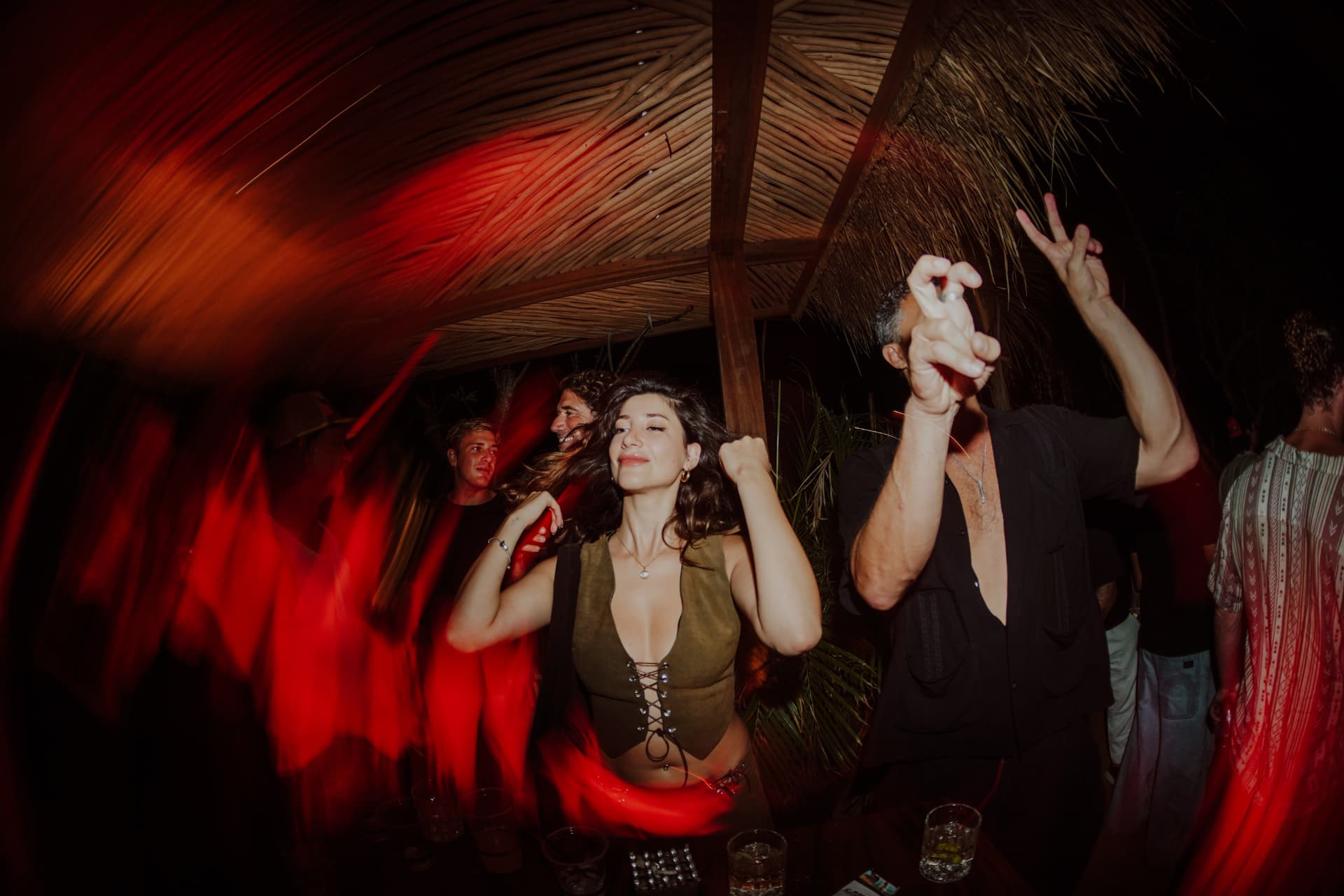 Guests dancing together beneath the woven garden roof at TAMAN
