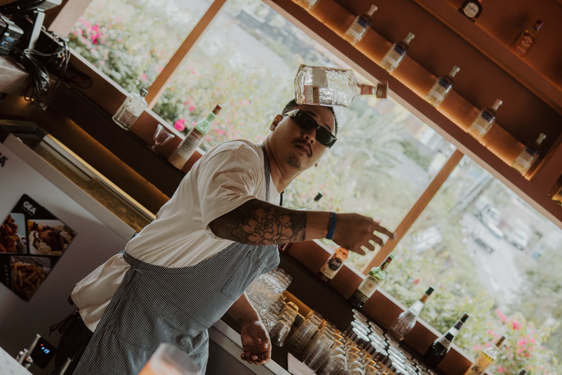 Bartender at TAMAN performing a flair move behind the bar