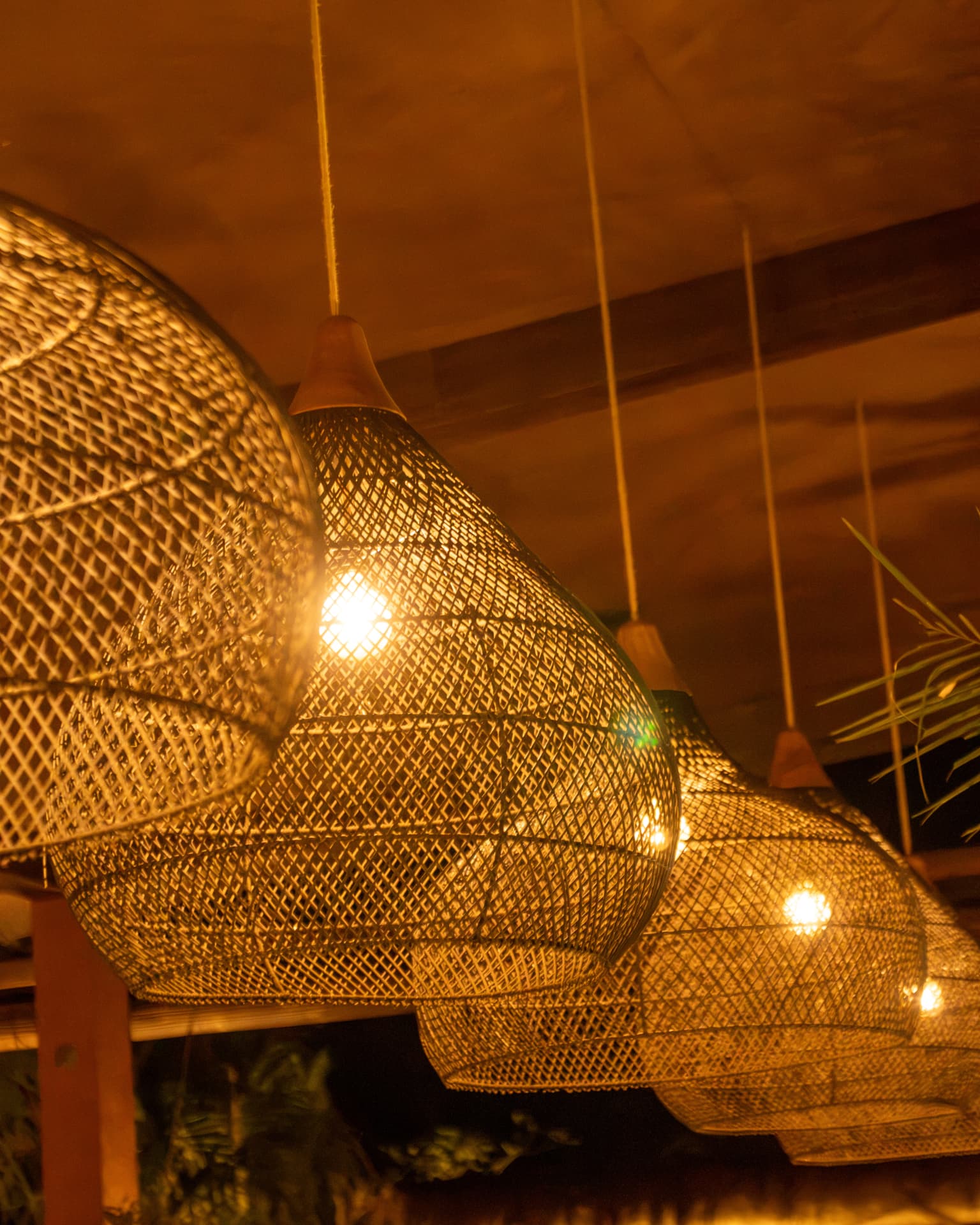 Handwoven pendant lights glowing above the garden bar